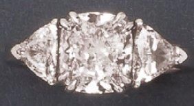 null Bague en or gris sertie d'un diamant coussin épaulé de deux diamants triangle....