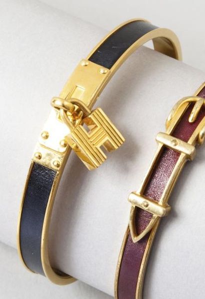 HERMÈS Paris made in France Bracelet jonc en métal doré et cuir noir retenant un...