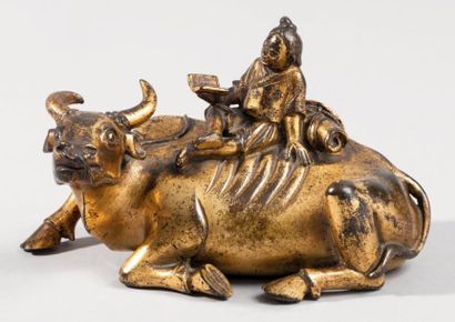 null Groupe en bronze doré représentant un enfant assis sur un buffle de rizière...