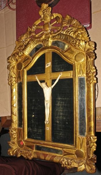 null CHRIST en os dans un cadre à fronton en bois sculpté et doré à parcloses à décor...