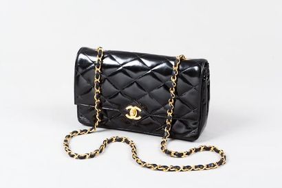 CHANEL Sac "2.55" 23 cm en cuir vernis matelassé noir, fermeture en métal doré siglé...