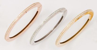 null Trois bracelets jonc ouvrant en or de trois couleurs ornés chacun d'une ligne...