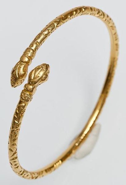 null Bracelet jonc ouvert en or jaune orné de deux têtes de serpent. P. 30,8g
