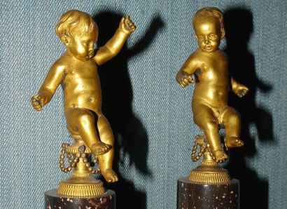 null Paire de statuettes en bronze doré représentant chacune un amour assis sur un...