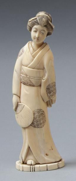 null Okimono en ivoire marin représentant une Geisha debout tenant un éventail. Japon,...