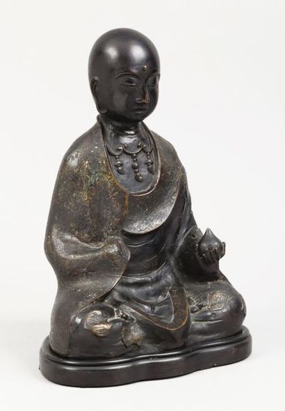 null Bouddha assis tenant un bouton de lotus en bronze de patine brune anciennement...