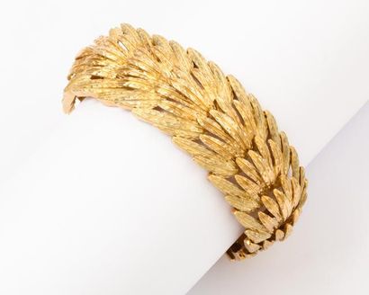null Bracelet articulé en or jaune mat et poli à décor de plume. P. 57g.