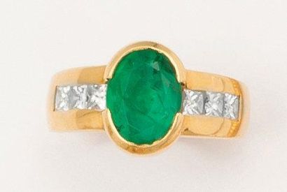 null Bague en or jaune ornée d'une émeraude ovale épaulé de diamants princesse. P....