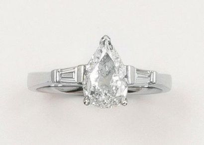 null Bague solitaire en or gris ornée d'un diamant taillé en poire épaulé de deux...