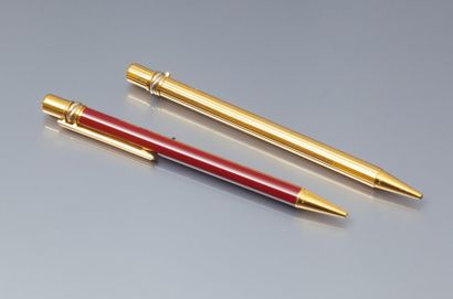 CARTIER Lot de deux stylos à bille en métal doré et émaillé. Signé Cartier