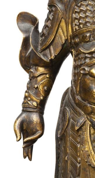  Sujet en bronze doré représentant GUANGMU TIAN WANG debout, vêtu d'une armure ornée...