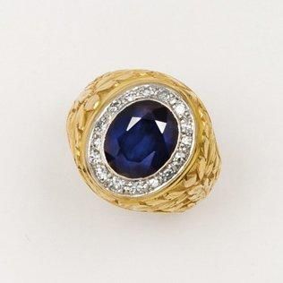 null Bague en platine et or jaune ciselé ornée d'une pierre bleue dans un entourage...