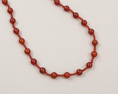CHANEL Sautoir composé de perles en cornaline sang de boeuf entrecoupé de trois petites...
