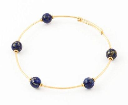 null Bracelet jonc en or jaune orné de boules de lapis lazuli. P. Brut 10,1g