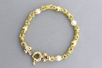 null Bracelet articulé en or jaune orné de perles de culture. P. 23,8g
