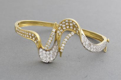 null Bracelet rigide ouvrant en or jaune et or gris à décor de rubans sertis de pierres...