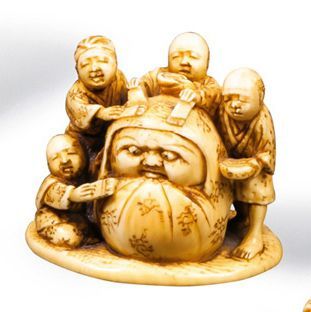null Netsuke en ivoire représentant trois personnages sculptant une poupée Daruma.Japon,...