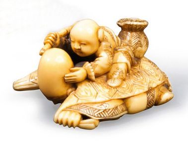 null Netsuke en ivoire représentant un enfant sur le crâne de Fukurokuju.Japon, période...