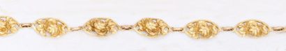  Bracelet articulé en or jaune à motif de fleurs. P. 18g.