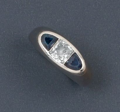 null Bague en or gris ornée d'un diamant taillé en brillant épaulé de pierres bleues....