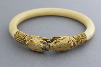 null Bracelet rigide en ivoire orné de deux têtes de serpent en or 9k. P. 39,7g.