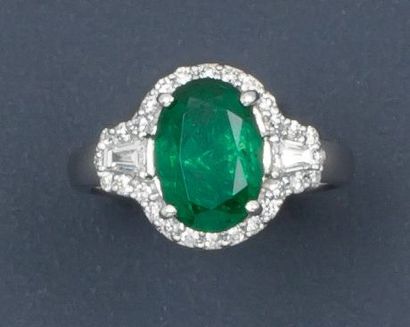 null Bague en or gris ornée d'une émeraude ovale dans un entourage de diamants taillés...