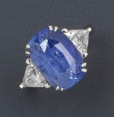 null Bague en or gris ornée d'un saphir taillé en coussin épaulé de deux diamants...