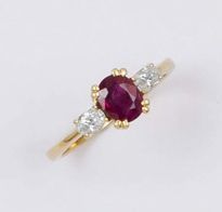 null Bague en or jaune ornée d'un rubis ovale épaulé de deux diamants taillés en...