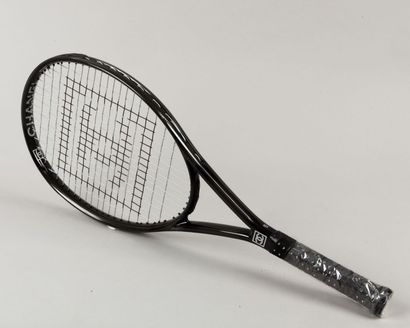 CHANEL Raquette de tennis en fibre noir, tamis siglée, grip ajouré laissant apparaître...