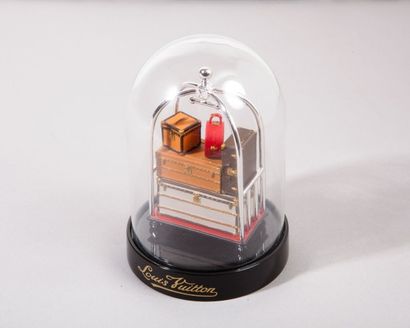 LOUIS VUITTON Globe en verre sur socle en bakélite noir figurant un trolley d'hôtel...