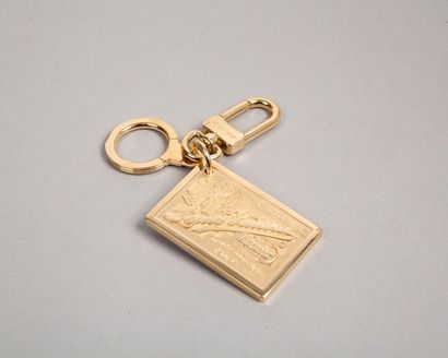LOUIS VUITTON Porte clefs en métal doré «Travelling requisites» sur plaque, mousqueton....