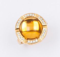 CHAUMET Bague en or jaune ornée d'une citrine cabochon bordée de diamants taillés...