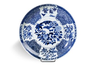 null Important plat en porcelaine émaillée blanc bleu à décor en réserve de feuillages,...