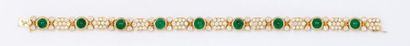 O.J. PERRIN Bracelet articulé en or jaune orné de neuf émeraudes cabochon alternées...