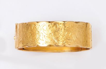 null Bracelet rigide ouvrant en or jaune ciselé à décor floral. P. 36,8g.