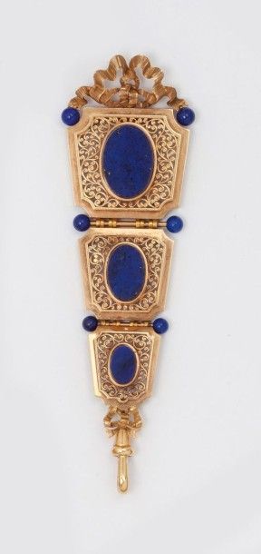 null Pendentif en or rose ajouré à décor de volutes et noeuds orné de lapis-lazuli....