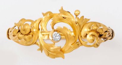 null Bracelet ouvrant en or jaune à décor de volutes et feuillages serti d'un diamant...