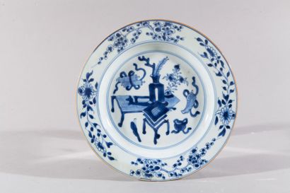 null Assiette en porcelaine à décor en camaïeu bleu d'objets mobiliers.

Chine, fin...