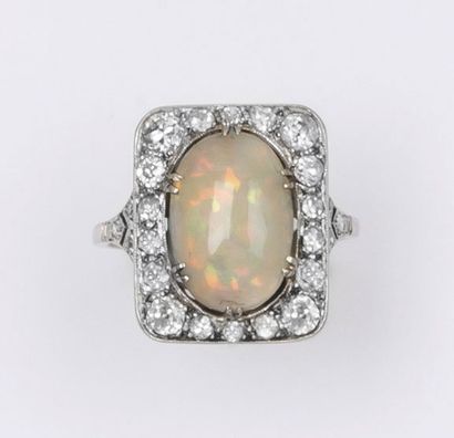 null Bague en or gris ornée d’une opale cabochon dans un entourage de diamants taillés...
