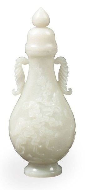 null Petit vase couvert en jade celadon de forme balustre, le corps sculpté de prunus...