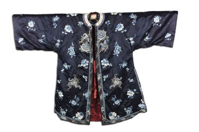 null Robe en soie à fond bleu nuit brodée de fleurs polychromes. 
Chine, vers 1900...