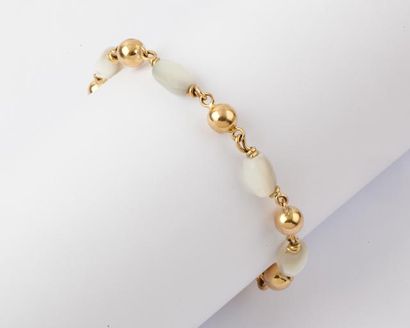 null Un collier et un bracelet en or jaune ornés de boules d’or alternées de nacre...