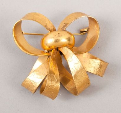 ANONYME Lot composé de trois broches en métal doré, l'une strassée figurant un noeud,...