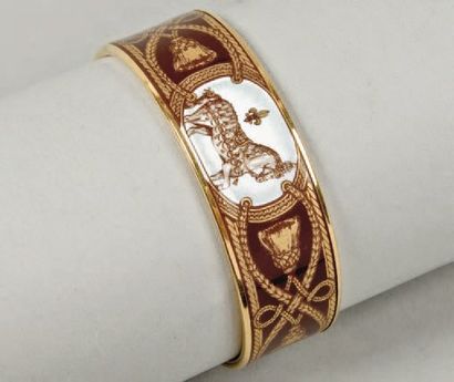 HERMÈS Paris made in France Bracelet jonc en métal doré émaillé à décors de chevaux...