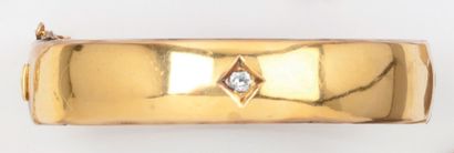 null Bracelet rigide ouvrant en or jaune orné d’un diamant de taille ancienne. Chaînette...