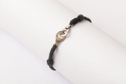 DINH VAN Bracelet sur cordon de soie noir orné de motifs «Menottes» en argent.
Signé...