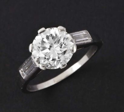 null Bague solitaire en platine ornée d'un diamant taillé en brillant épaulé de deux...