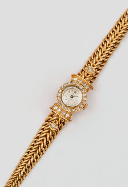 null CURTIS - Bracelet-montre de dame en or jaune. La lunette et les attaches serties...