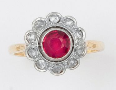 null Bague en or jaune et or gris ornée d’une pierre rouge dans un entourage de diamants...