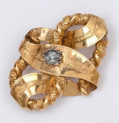 null Broche « nœud » en or jaune ciselé ornée d’un diamant taillé en rose. Époque...